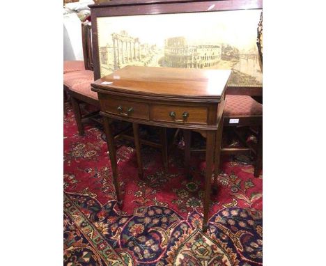 An Edwardian Georgian style card table, the bow front swivel top over a baize top, fitted two frieze drawers on tapering stra