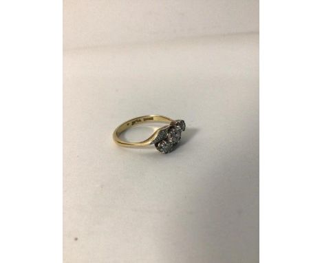 An 18ct gold crossover ring, set three diamonds flanked by two panels with multiple diamond chips (M) (2.84g)