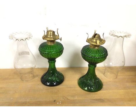 A pair of green glass oil lamps, complete with shades (lamp: 24cm excluding shade)