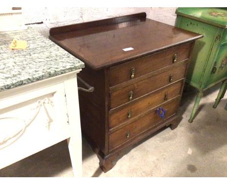 A late 19thc chest of drawers, the rectangular top with ledge back and overhang to either side, above four drawers, on shaped