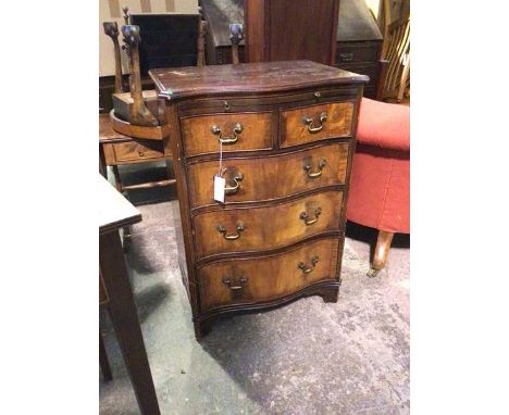 A first half of the 20thc Georgian inspired chest of drawers, with serpentine front above brush slide, fitted two short drawe