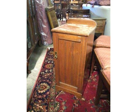 An Edwardian bedside cabinet, the rounded ledge back above a top with moulded edge, fitted single panel door enclosing an int