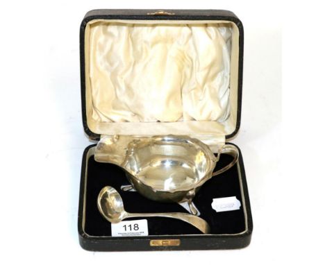 A silver sauceboat and ladle, in fitted case 