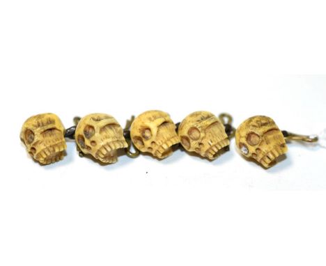 A set of five circa 1900 carved ivory skull dress buttons, measure 1.4cm by 1cm approximately  The buttons are in good condit