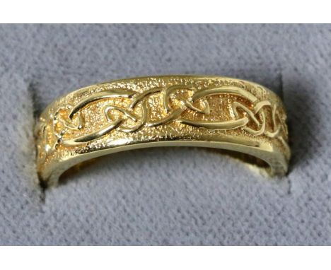 An 18 carat gold Celtic motif band ring, finger size M1/27.4 grams 