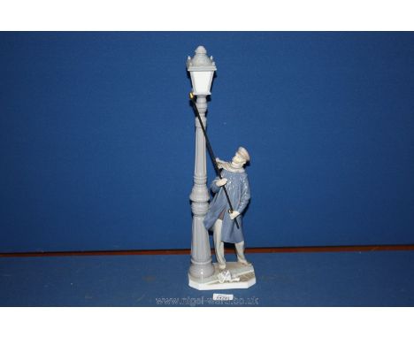 A Lladro figure of a man lighting the street lamp