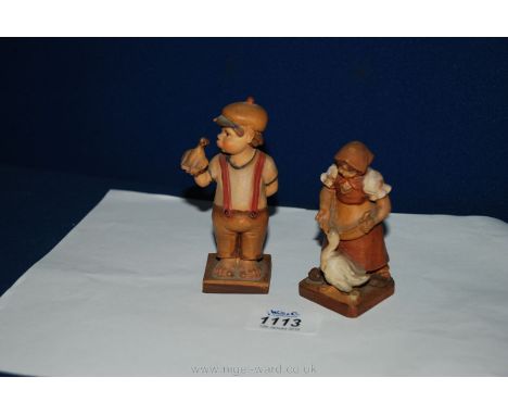 Two wooden German Hummel style figures - a girl with a goose and a boy with a bird on his hand a/f