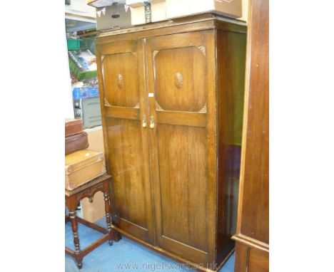 An Oak finish double-doored wardrobe, probably circa 1920. The interior with hanging space and an upper hat shelf to one side