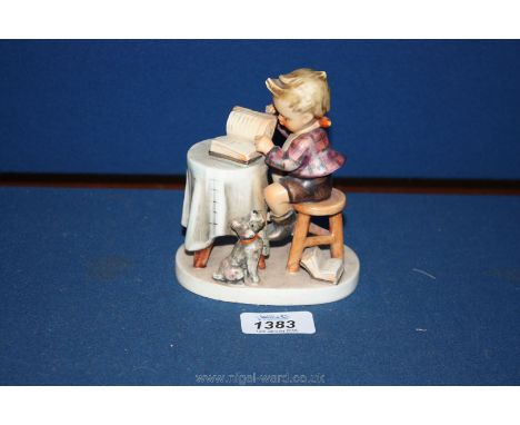 A Hummel figure of a small boy reading his book with a dog sat by his feet
