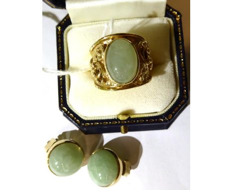A 9 carat gold jade ring, an oval cabochon jade in a rubbed over setting, to a tapering shank with floral detail, finger size