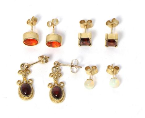 A pair of 9 carat gold oval fire opal stud earrings, a pair of 9 carat gold square cut garnet stud earrings, a pair of 9 cara