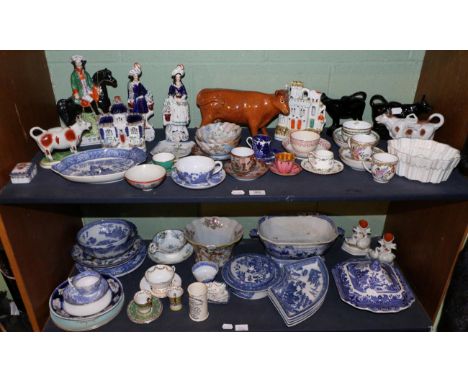 A group of 19th century and later blue and white transfer printed ceramics, various cups and saucers, etc (on two shelves) 