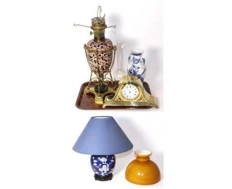 Brass and Imari style pottery oil lamp; a Chinese blue and white vase; brass mantel clock; and a blue and white table lamp (4