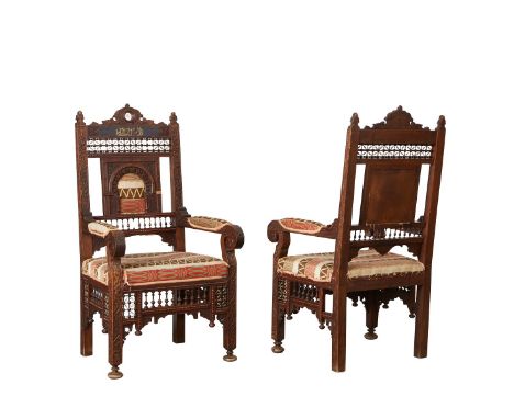 Pair of Syrian carved wooden armchairs. The intricately carved chairs are paneled throughout with mashrabiya style latticewor