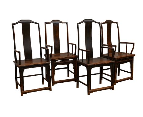 Set of four Chinese hardwood yokeback armchairs. Each with a curved backsplat. Two chairs with a pierced decorative skirt.Pro