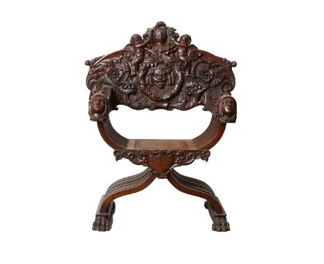 Neoclassical Savonarola or Dagobert style folding armchair profusely carved with Roman motifs along the backrest, armrests, a