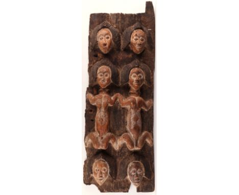 Carved African wood panel with figures surrounded above and below by heads. The figures incised with decoration possibly repr