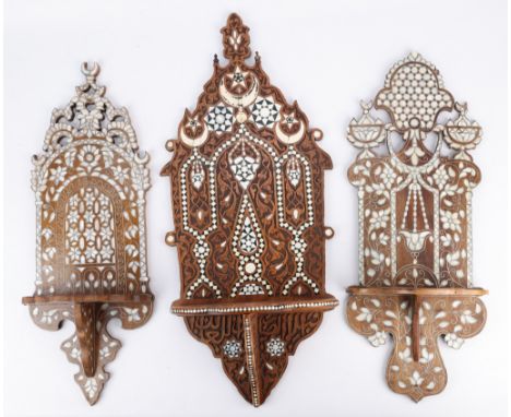 Group of three Syrian mother of pearl inlaid wooden wall shelves. The intricately carved wood of each is inlaid with designs 