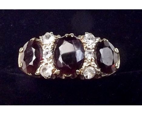 A 9 carat gold ring set three garnets and white stones, size P 1/2