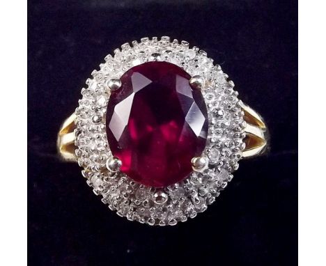 A silver gilt dress ring set red stone within diamond surround, size P