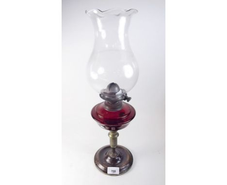 A Victorian oil lamp with ruby glass reservoir