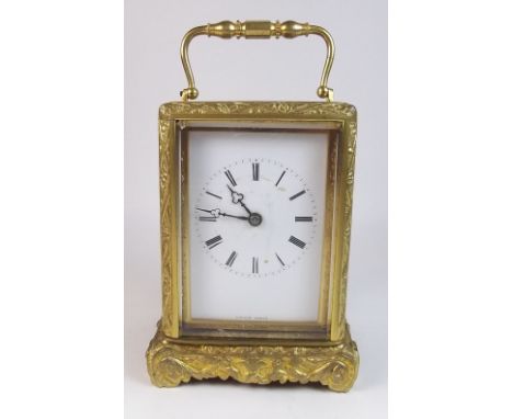 A 19th century French striking carriage clock by Lucien Paris with cast scrollwork case, key and leather travelling case