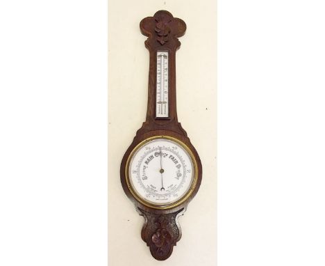 A Victorian oak barometer/thermometer with floral carved decoration