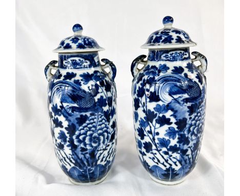 A pair of Chinese 18th/19th Century lidded vases with marks for Kangxi period, blue and white with birds and flowers (one a.f