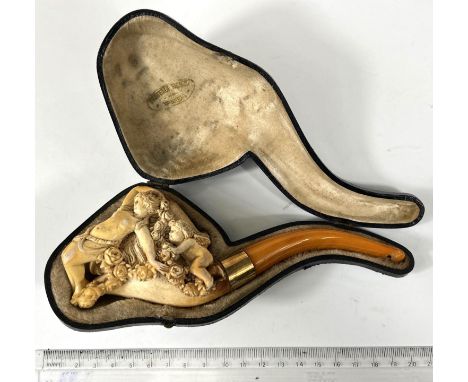 A cased amber and Meerschaum pipe with extensive relief decoration of a reclining woman in flowers with cherub, with yellow m
