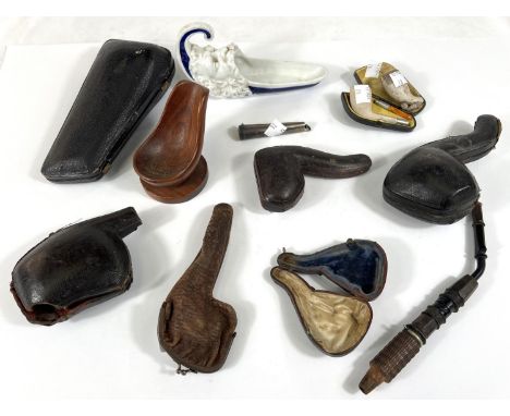 A small cased amber and Meerschaum pipe, and ceramic pipe stand; a white metal cigarette holder case; various pipe cases etc.
