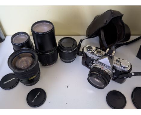 An Olympus OM-1 vintage SLR camera and a selection of lenses