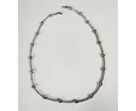 A silver necklace set with rows of simulated diamonds interspersed with large slightly coloured stones; a hinged bangle set w