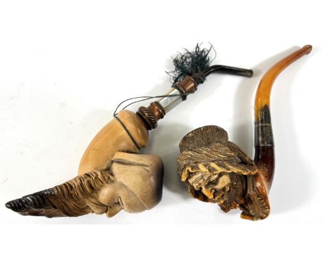 An amber and Meerschaum pipe with silver mount, depicting an arab man's head with beard and turban; a Meerschaum pipe depicti