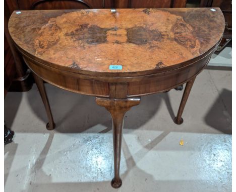 A 19th Century burr walnut demi line fold over card table with rear extending leg cabriole with pad feet, green baize.