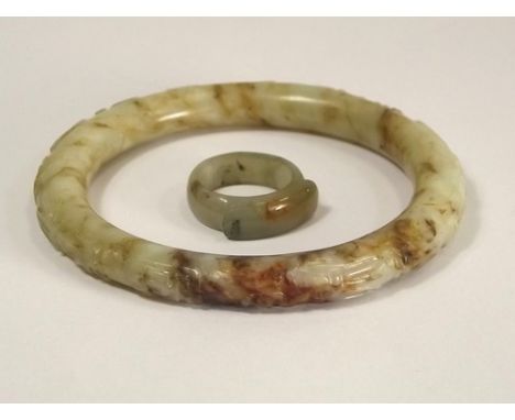 CARVED JADE.
A carved jade bangle & a jade finger ring.