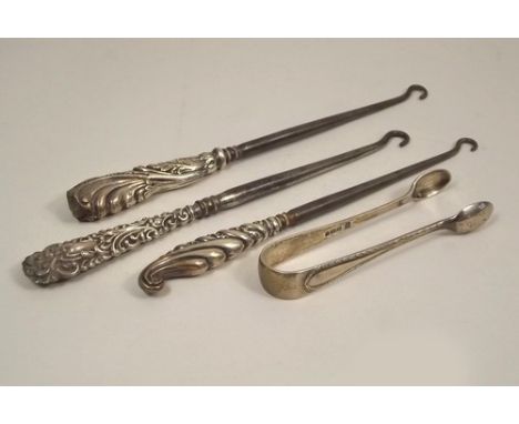 BUTTON HOOKS ETC.
Three silver mounted button hooks & a pair of silver sugar tongs.