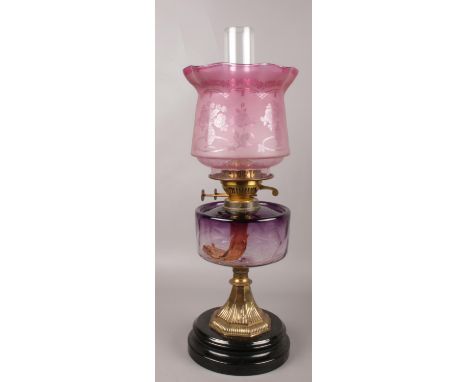 A Victorian brass &amp; glass oil lamp. Cranberry glass shade, by Sherwood Birmingham. 57cm height.  