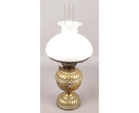 A brass oil lamp with milk glass shade.  