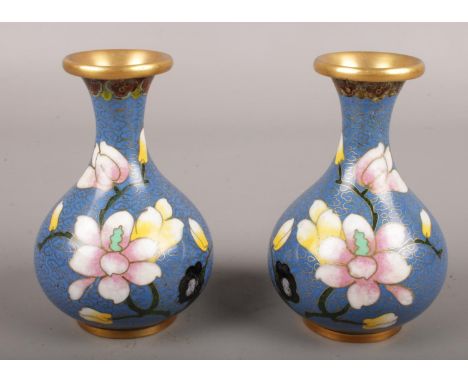 A pair of blue ground closonnie vases. Decorated with flowers. (11cm tall)  Loss to enamel on under side of rim on one vase.