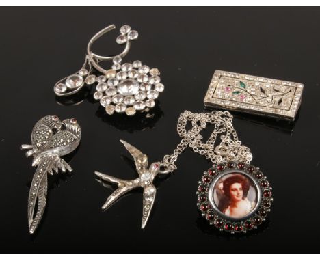 A collection of silver jewellery. Includes four brooches and a bird pendant on chain.  