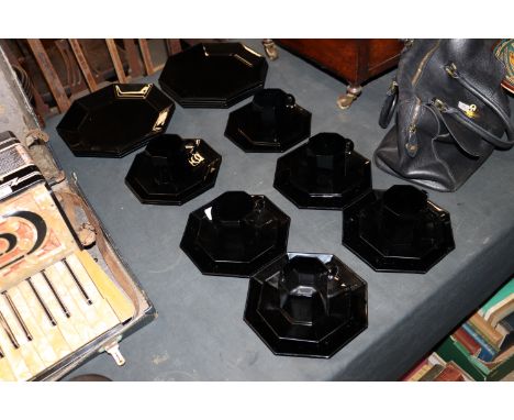 A collection of French black glass Arcoroc dinner plates, cups and saucers 