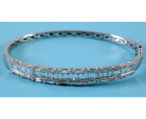 An 18ct white gold and diamond bangle, set baguette and brilliant cut stones, boxed  See illustration