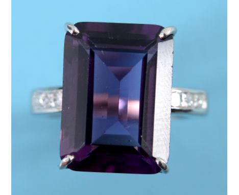 An 18ct white gold amethyst and diamond ring, the large central amethyst flanked by princess cut diamonds set into the should