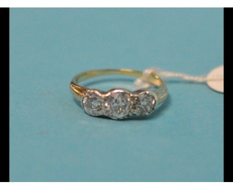 A three stone diamond ring, in a white and yellow coloured metal setting, approx. ring size M 