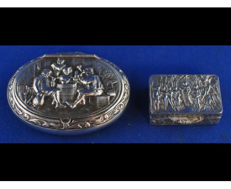 A Continental silver coloured metal oval snuff box, decorated figures drinking around a barrel, and a similar silver snuff bo