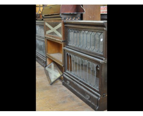 Two pairs of Globe Wernicke oak bookcases, with leaded glass glazed doors, and a similar Macey oak three section bookcase (da