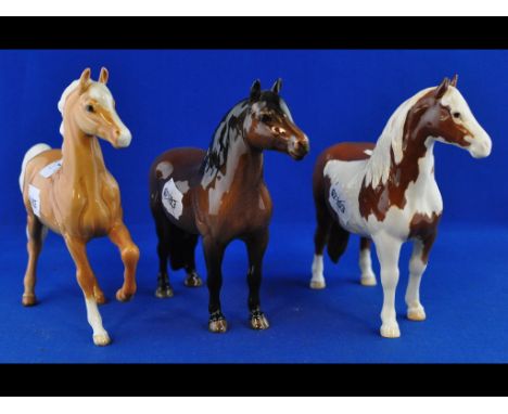 A Beswick Dartmoor Pony, 1642, a Prancing Arab, palomino, 1261, and a Pinto Pony, 2nd version, skewbald, 1373 (ear a.f.), all