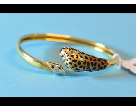 A 14ct gold leopard's head bangle, with enamel decoration and set emeralds and diamonds