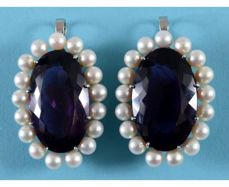 A near pair of white coloured metal oval pendants, each set a large amethyst within a surround of pearls (2)  See illustratio