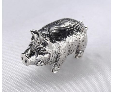 A miniature model of a silver pig with engraved detailing and tusks. Stamped sterling.